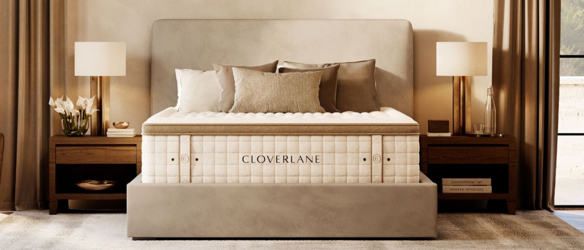 Şık ve nötr bir yatak odasında bej bir yatak temeli üzerine yerleştirilen Cloverlane Hybrid yatak