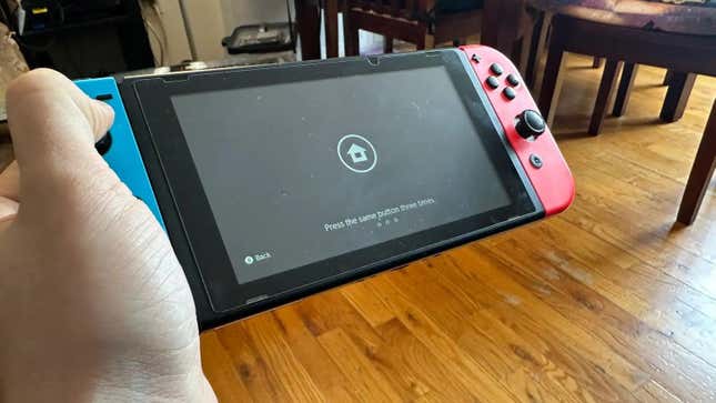 Elinde ana giriş ekranını gösteren bir Nintendo Switch konsolu.