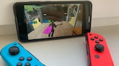 Denetleyiciyi akıllı telefona bağlayın: Nintendo Switch Joy Eksileri kırmızı ve mavi akıllı telefonun önünde