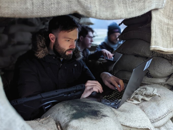 Savunma sığınağında dizüstü bilgisayarın başında duran adam