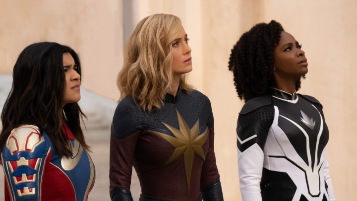 Iman Vellani, Brie Larson ve Teyonah Parris ekranın dışında bir şeye bakıyor.