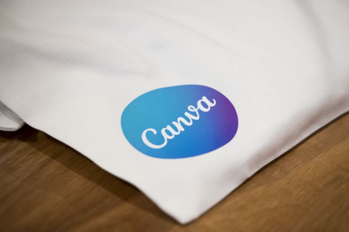 Masanın üzerinde duran çantanın üzerindeki Canva logosu.