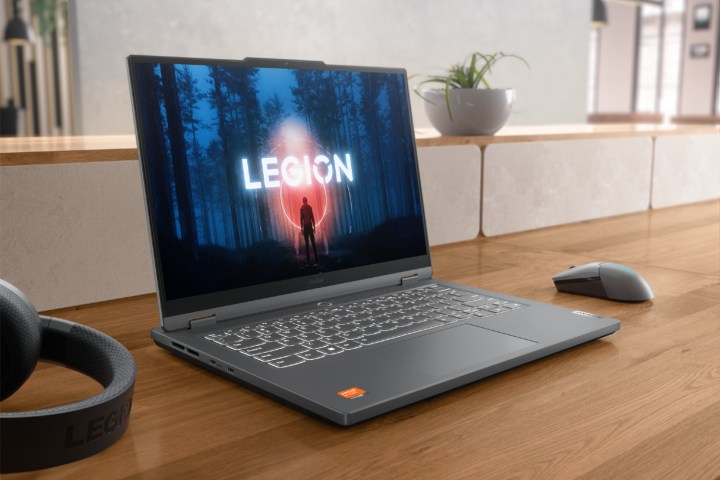 Legion Slim 5 14, üzerinde çevre birimleri bulunan bir masanın üzerinde.