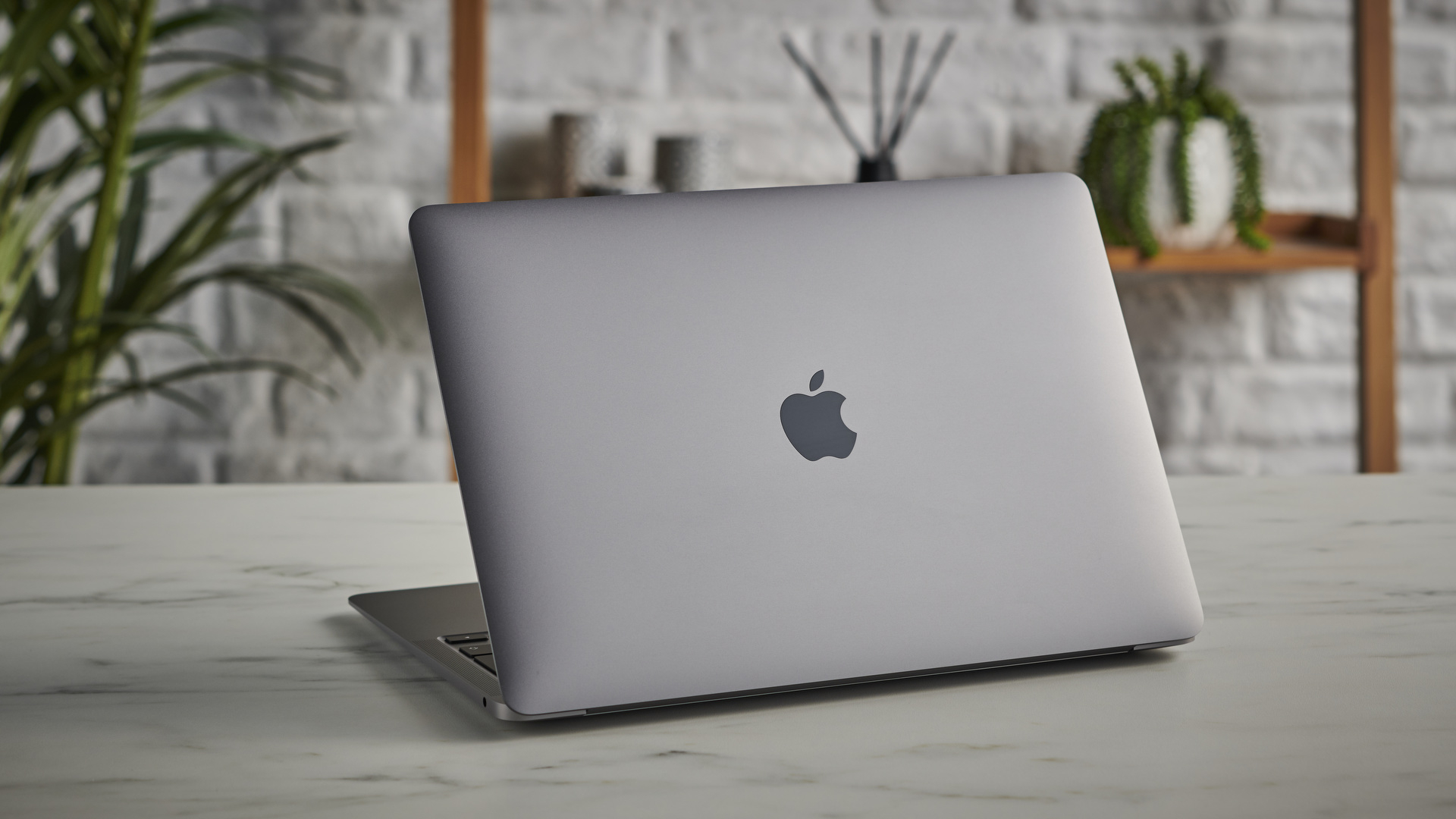 Kapağı ve Apple logosunu gösteren bir masanın üzerindeki MacBook Air M1