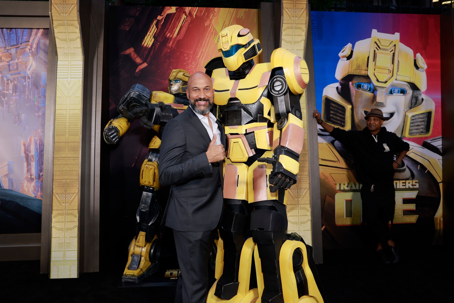 Keegan-Michael Key, Transformers One galasında bir transformatörün önünde poz veriyor