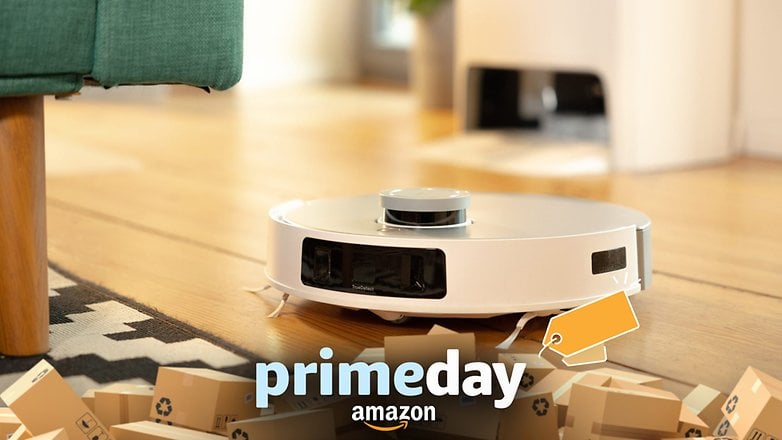 Amazon Prime Day reklamının yer aldığı yeşil bir kanepenin yanındaki ahşap zemin üzerinde beyaz bir Ecovacs Deebot T20 Omni robot elektrikli süpürge.