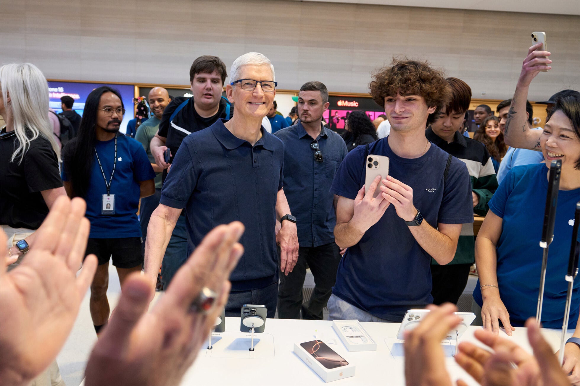 Apple CEO'su Tim Cook (L) başka bir iPhone 16 modelinin satışını izliyor. Resim kredisi-Apple - iPhone 16 serisinin piyasaya sürülmesiyle birlikte dünya genelindeki Apple Mağazaları geçen Cuma günü kalabalıktı