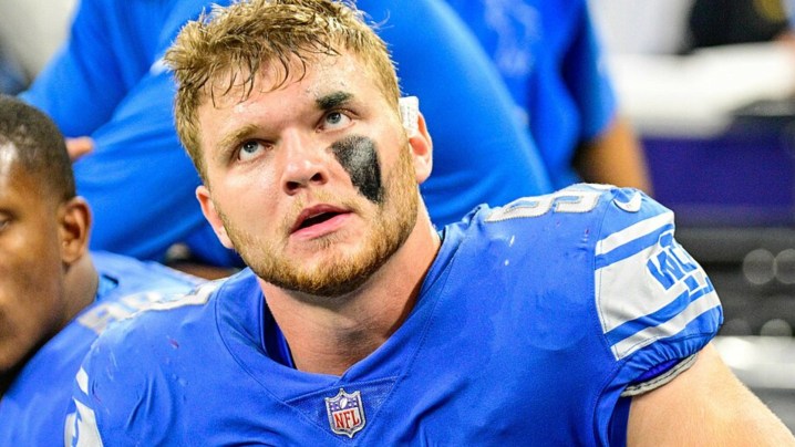 Detroit Lions'tan Aidan Hutchinson oturup bakıyor.