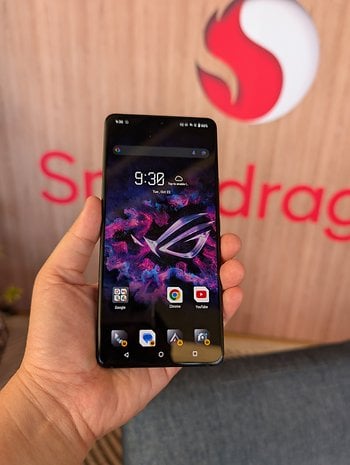 Bir kişi, uygulama simgelerinin bulunduğu renkli bir ekranı gösteren Asus ROG Phone 9'u tutuyor