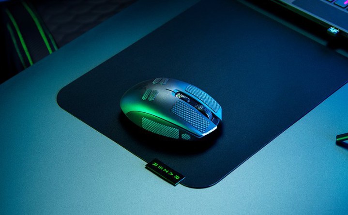 Masanın üzerindeki fare altlığının üzerinde Razer Orochi V2.