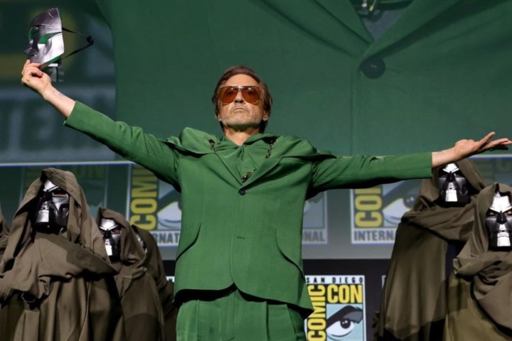 Robert Downey Jr. bir maske tutar ve poz verir.