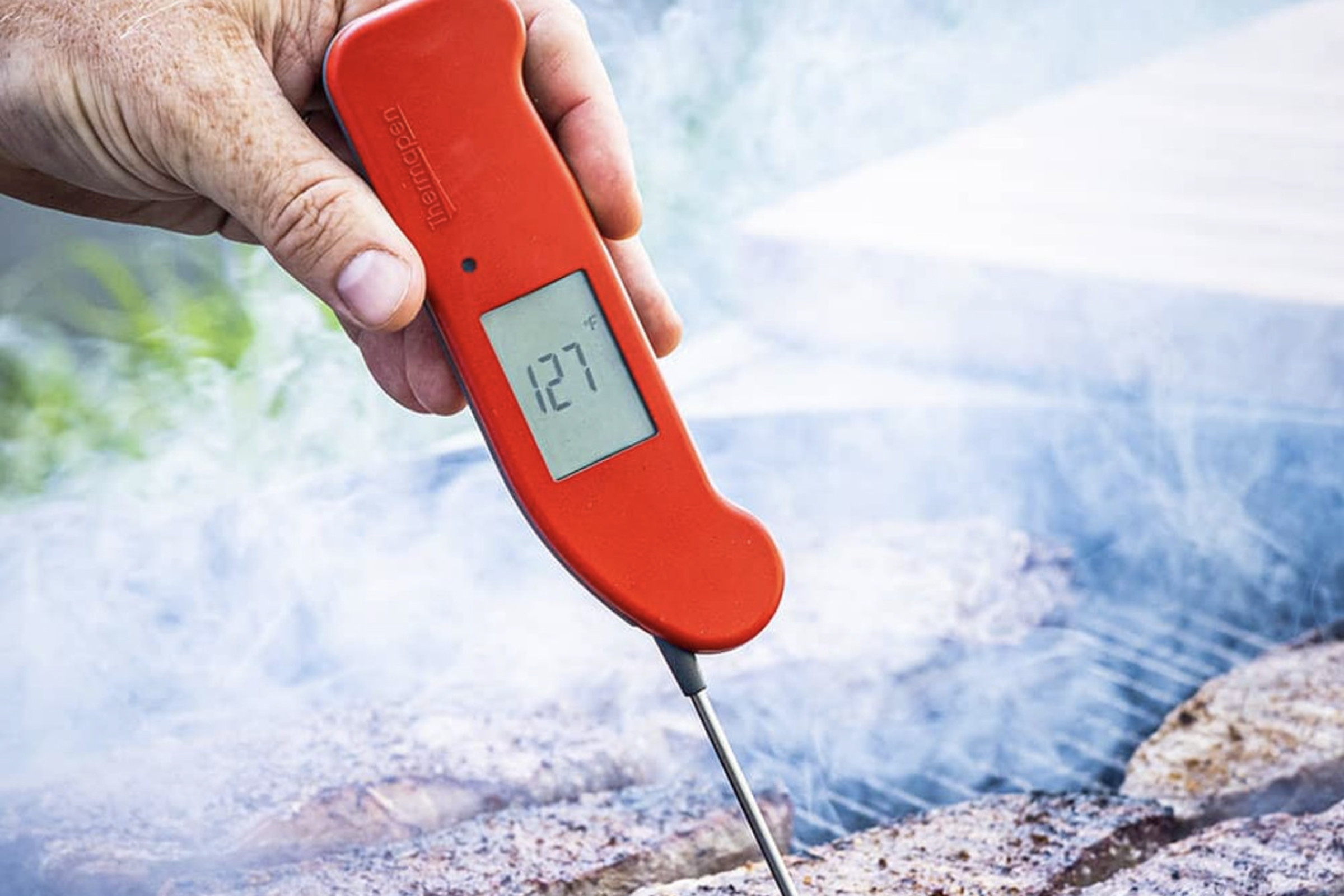 Thermapen One termometresini ızgara bifteğin içinde tutan el.