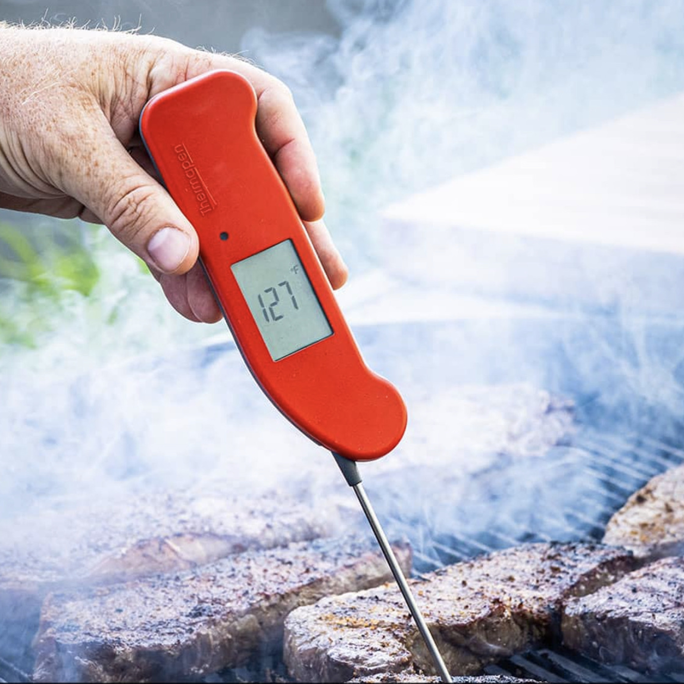 Thermapen One termometresini ızgara bifteğin içinde tutan el.