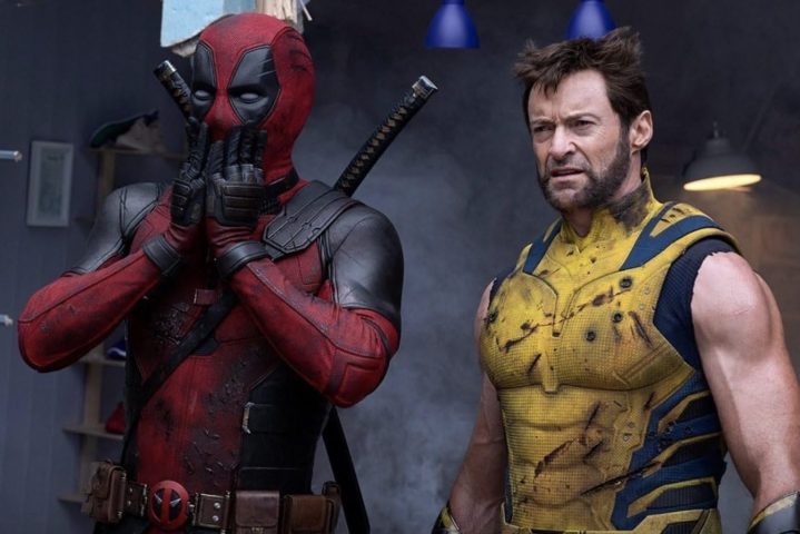 Deadpool, Wolverine yanında dururken ellerini ağzına koyuyor.