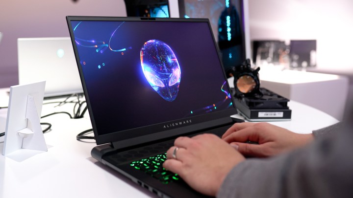 Alienware m18 dizüstü bilgisayarda yazı yazan biri.