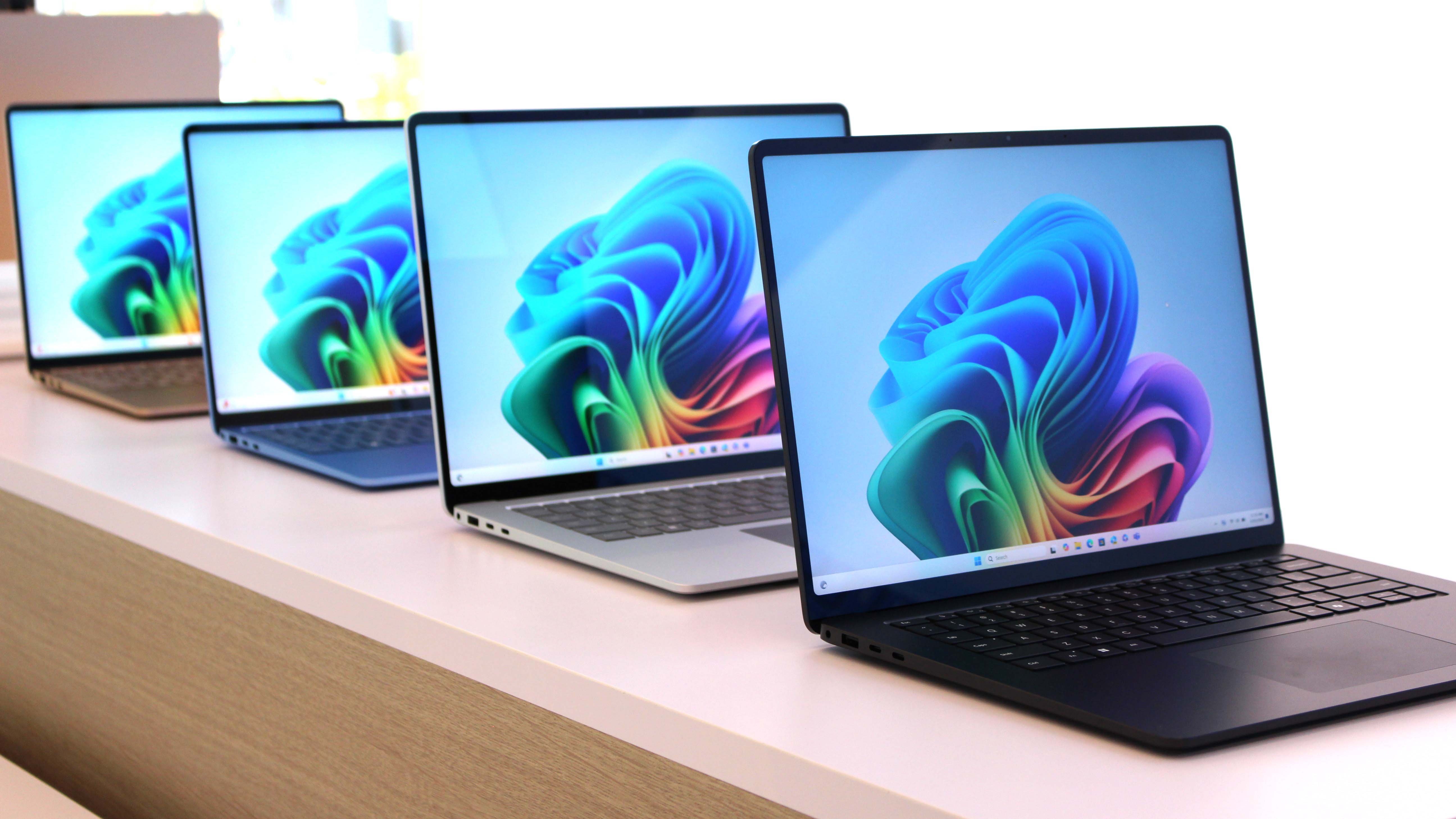 Multiple Surface Laptop 7'ler ekranları açık şekilde arka arkaya oturuyor.