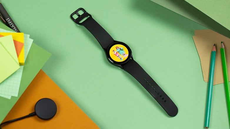 Samsung Galaxy Watch 4 yeşil kağıt üzerinde bir masanın üzerinde yatıyor