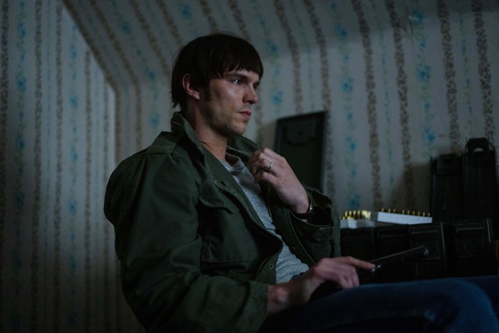 Nicholas Hoult, Teşkilat'ta yeşil bir askeri ceket giyiyor.