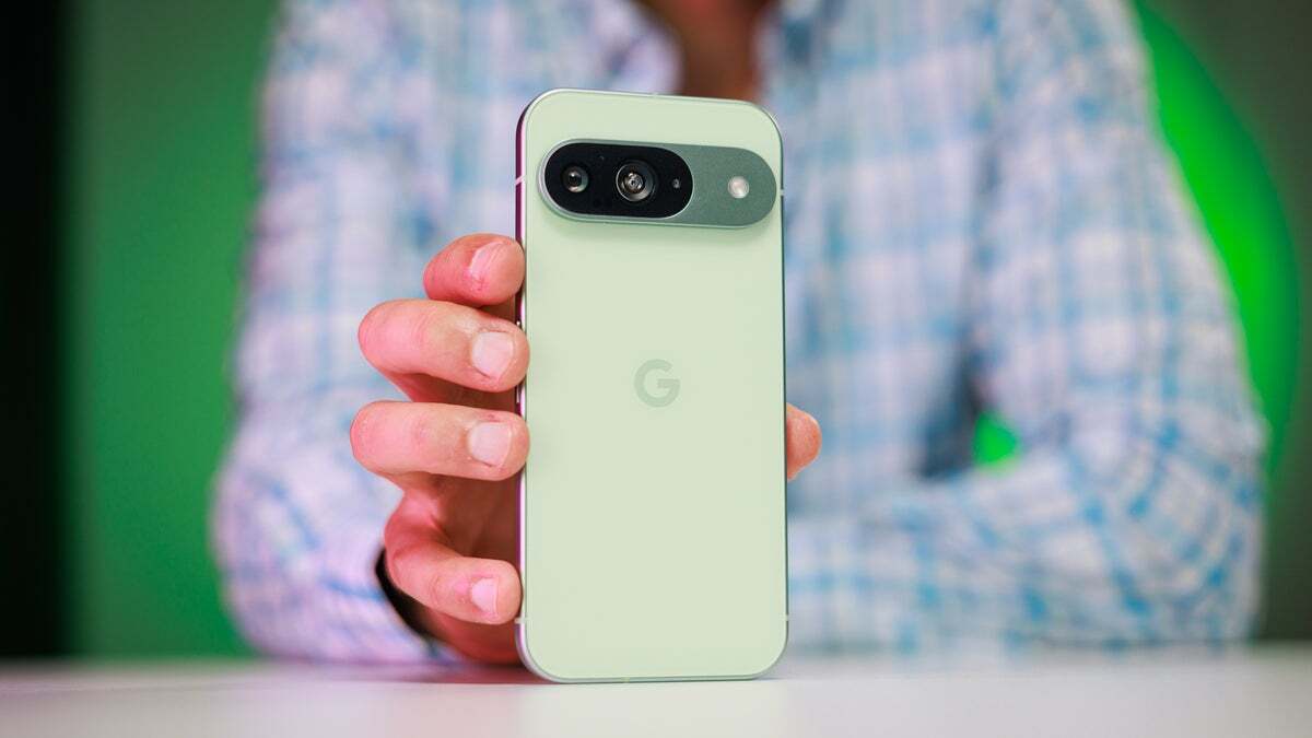 Pixel 9'u tutan ve arkasını gösteren bir kişi. 