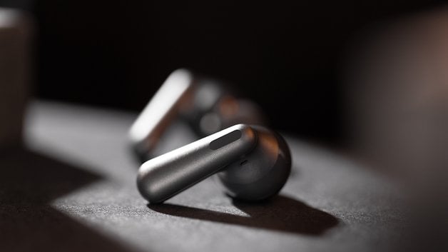 Karanlık bir yüzeyde OnePlus Nord Buds 3 Pro kablosuz kulaklığın yakın çekimi.