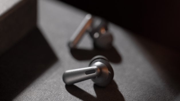 Karanlık bir yüzeyde OnePlus Nord Buds 3 Pro kablosuz kulaklıkların yakın çekimi.
