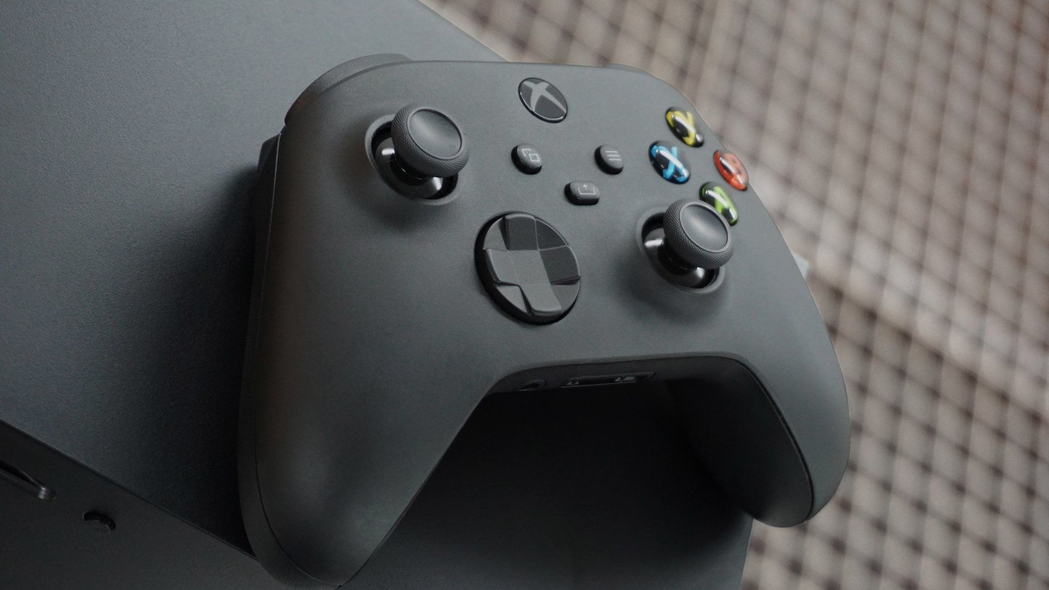 Xbox Series X'in üstünde siyah bir Xbox Kablosuz Oyun Kumandası.