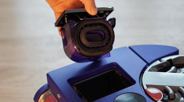 Bir el, Dyson 360 Vis Nav elektrikli süpürgenin üzerinde bir filtre tutuyor.