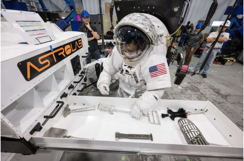 NASA astronotu Jessica Watkins, NASA'nın Johnson Uzay Merkezi'ndeki testler sırasında Astrolab'ın FLEX ay arazi aracının saklama çekmecesinden bir ay jeolojisi aracı alıyor. Kredi bilgileri: NASA/Robert Markowitz Yeni Ticari Artemis Moon Rovers NASA'da Test Ediliyor