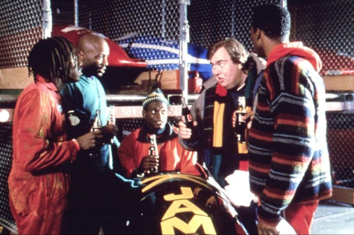 John Candy, Cool Runnings'de ekibiyle kızak etrafında konuşuyor.