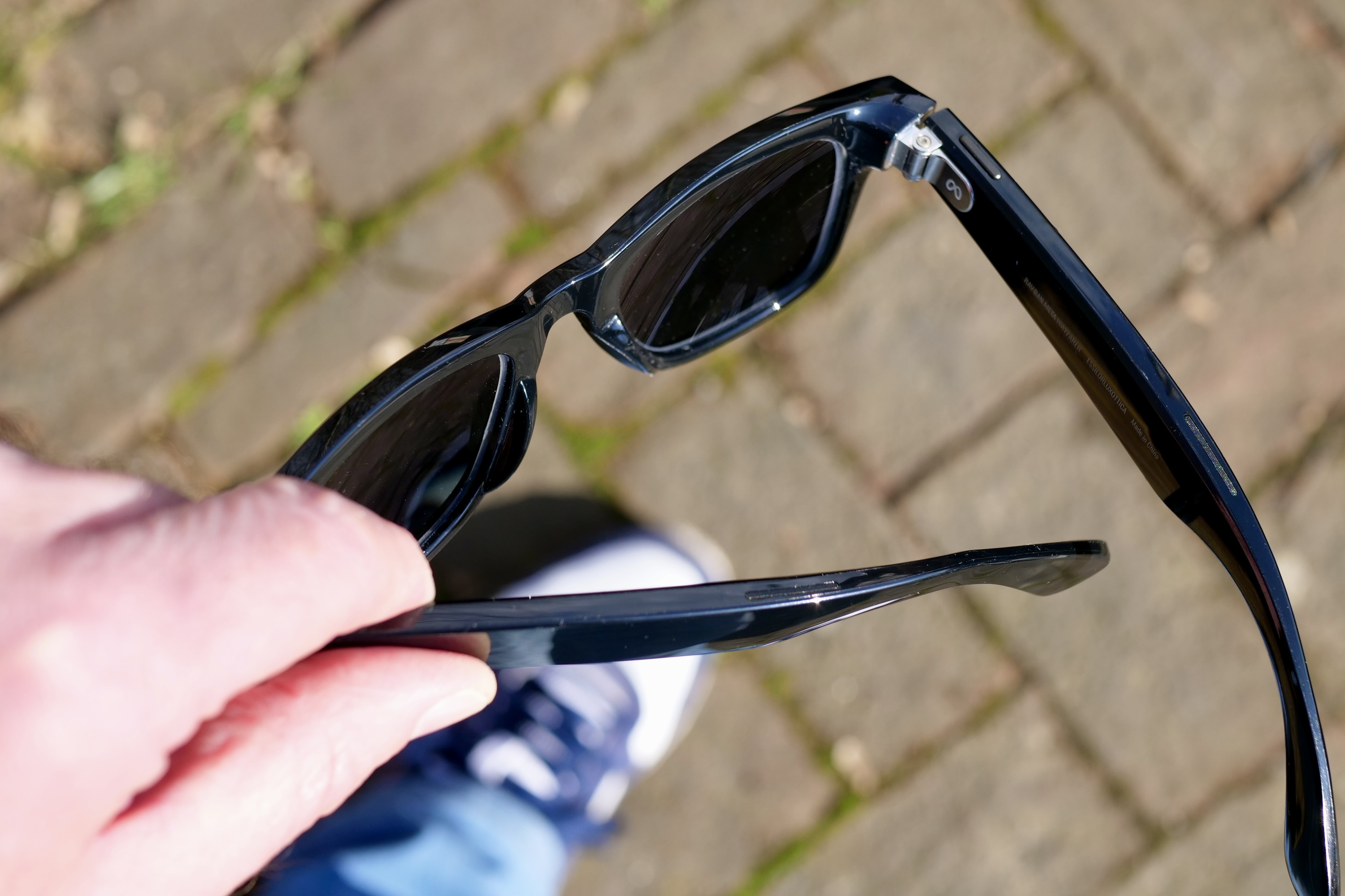 Ray-Ban Meta akıllı gözlüklerini tutan bir kişi.