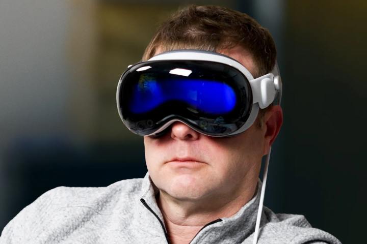 Apple Vision Pro kulaklığı takan bir kişi.