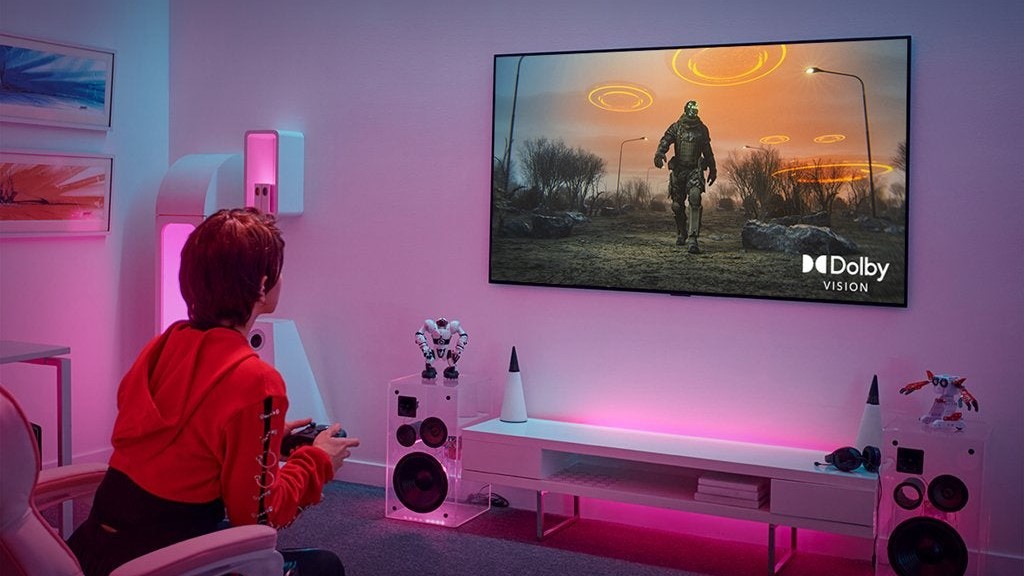 LG OLED TV'nin önünde oturan bir oyuncu.
