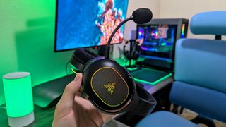 Elde tutulan ve çıkarılabilir mikrofonunu öne çıkaran bir Razer Barracuda X Chroma kulaklık.