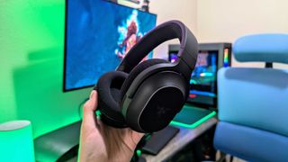 RGB aydınlatması devre dışı bırakılmış halde elde tutulan bir Razer Barracuda X Chroma kulaklığı.