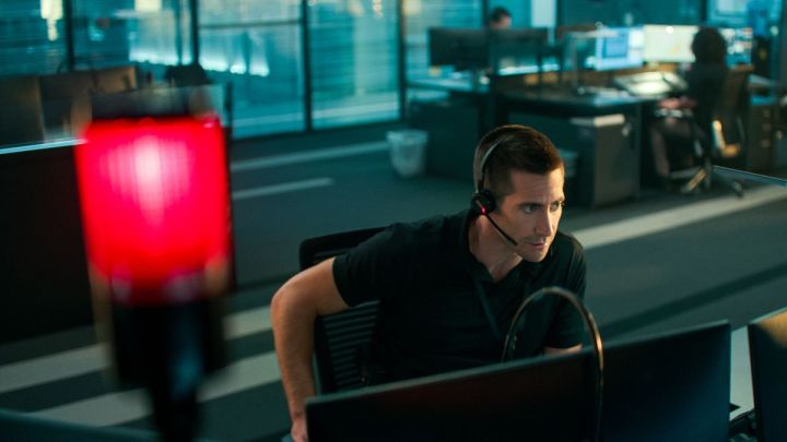 Jake Gyllenhaal, The Guilty'de bir masada oturuyor.