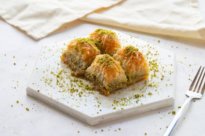 Üzeri fıstıkla süslenmiş bir tabak baklava. Üzeri fıstıkla süslenmiş bir tabak baklava.