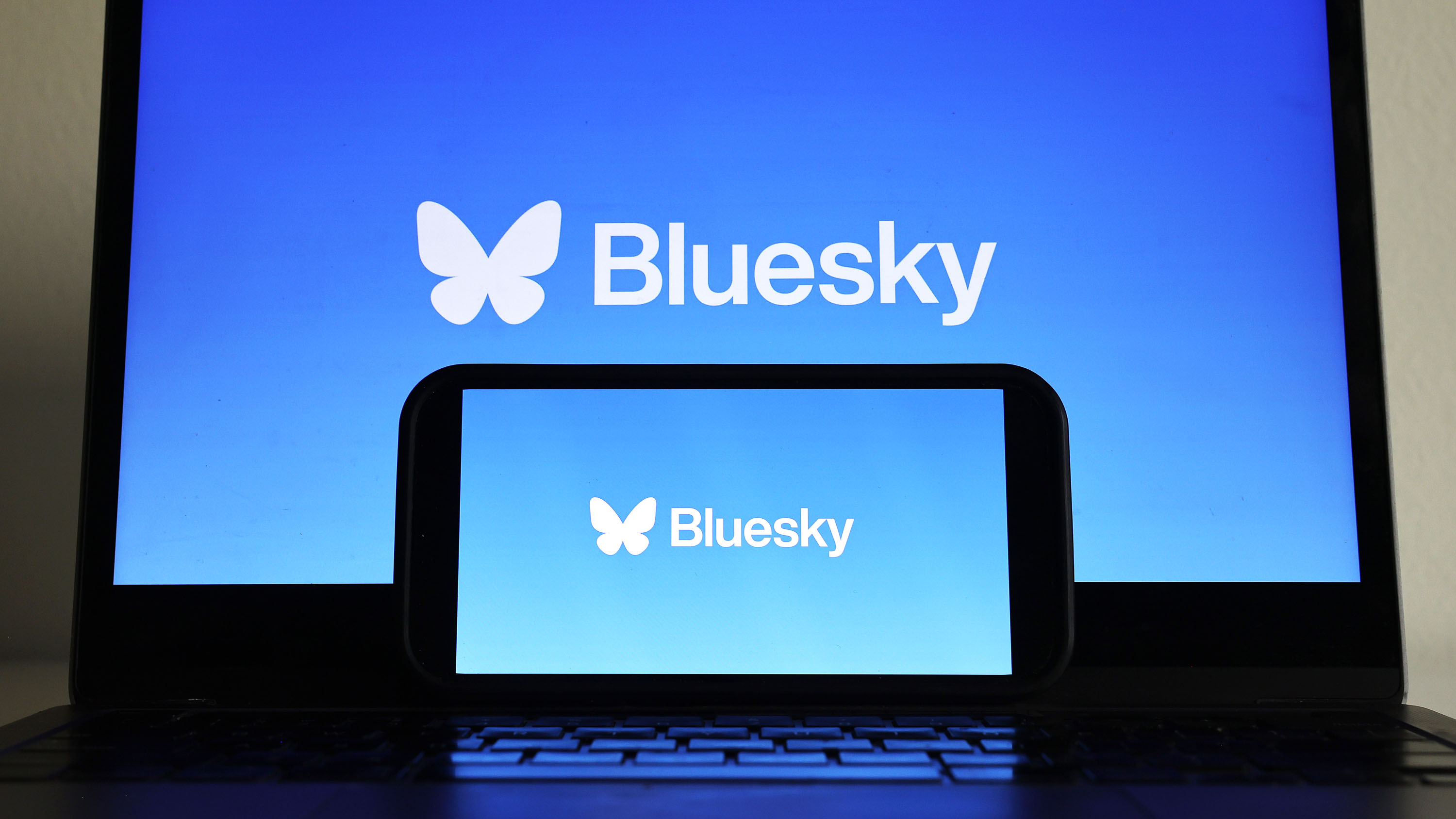 Bu fotoğraf illüstrasyonunda Bluesky logosu bir cep telefonu ve bilgisayar monitöründe görüntüleniyor.