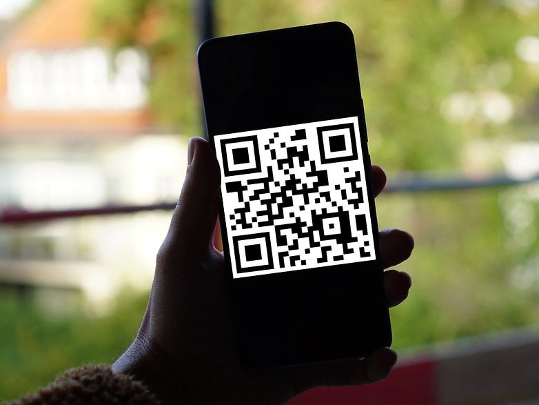 Bir elinde QR kodu olan akıllı telefon