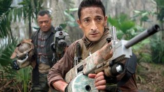 Royce rolünde Adrien Brody'nin ve Noland rolünde Laurence Fishburne'un büyük silahlarla ormanda süründüğü Predators filminden bir kare.