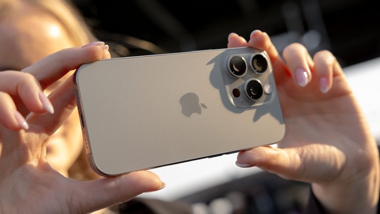 Bir kişi, arka tasarımını ve kamerasını gösteren bir iPhone 16 Pro'yu tutuyor.