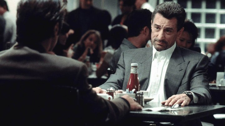 Genç Robert De Niro, bir restoranda başka bir adamla masada oturuyor ve Heat'ten bir sahneden etkilenmemiş görünüyor.