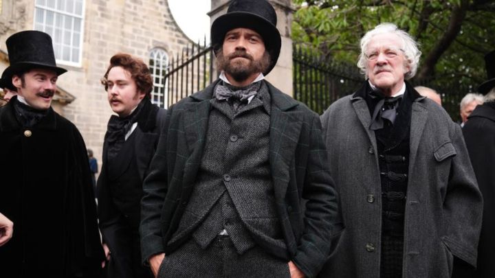 Guillermo del Toro'nun Frankenstein'ında dışarıda dururken ileriye bakan bir grup Viktorya dönemi adamı.