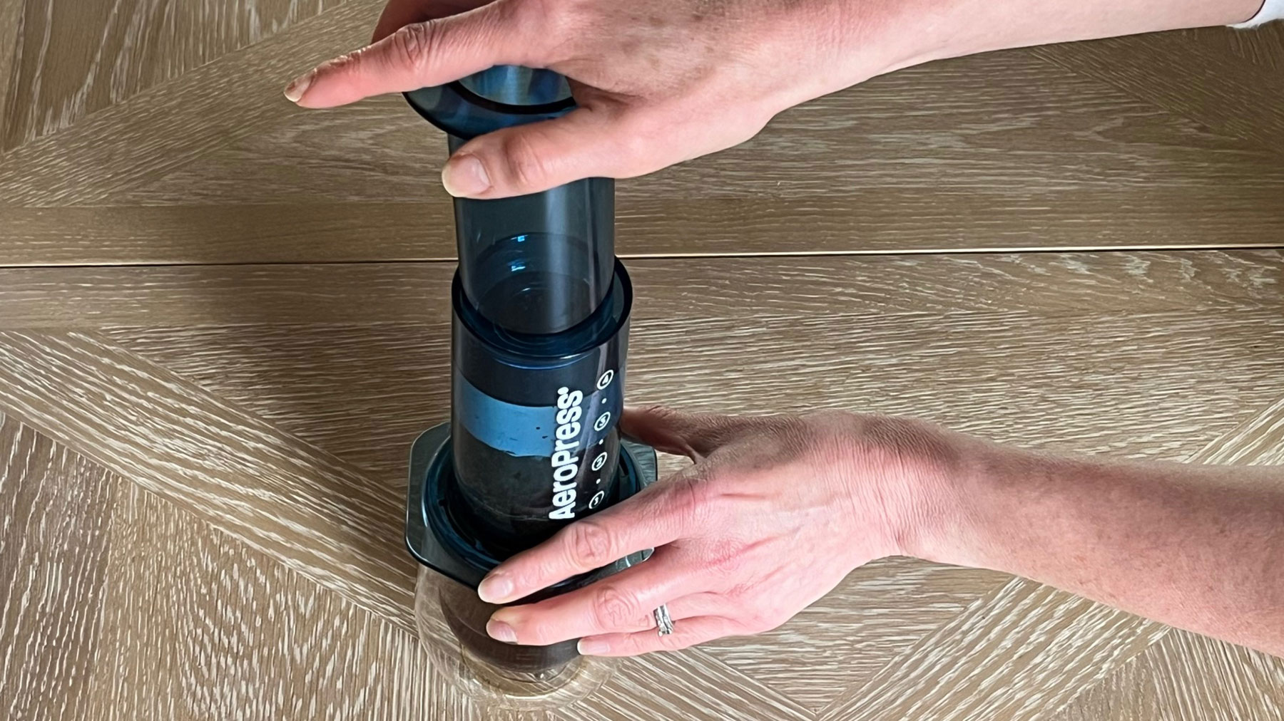 Piston, kahvenin şeffaf bir bardağa filtrelenmesiyle AeroPress'e bastırılıyor