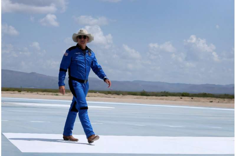 Jeff Bezos, 20 Temmuz 2021'de Van Horn, Teksas'ta uzaya uçtuktan sonra Blue Origin'deki New Shepard'ın yakınında yürüyor
