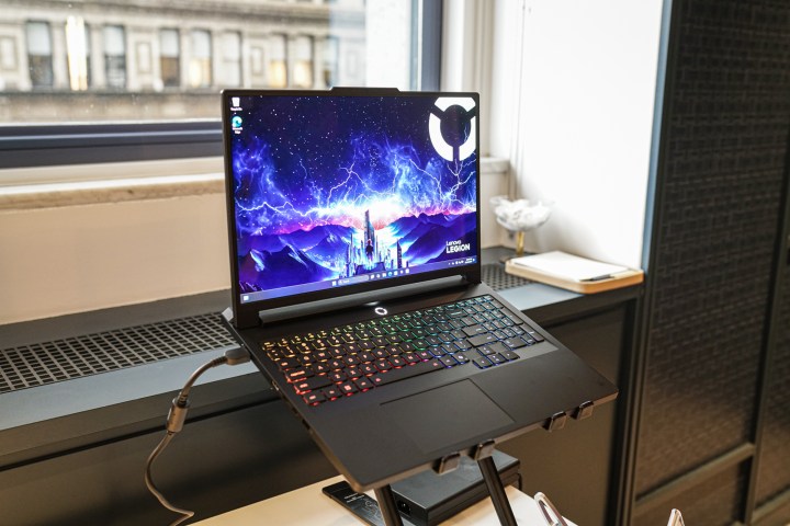 Lenovo Legion Pro 7i dizüstü bilgisayar pencerenin önünde duruyor.
