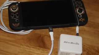 AVerMedia Elite Go GC313 Pro şarj ünitesi ve beyaz renkli yakalama kartı kombinasyonu.