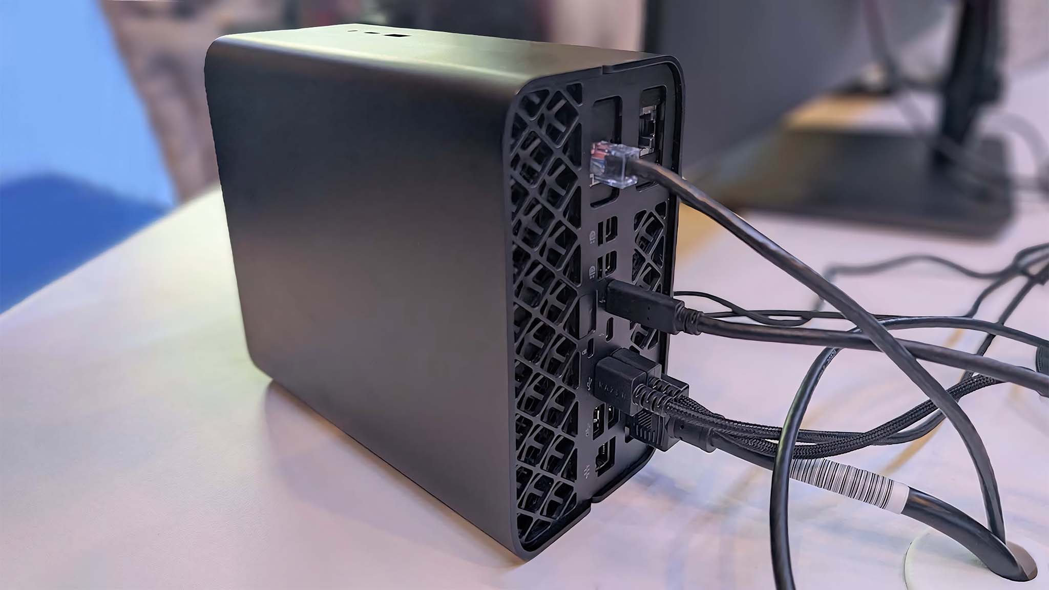 Bağlantı noktalarına çeşitli kabloların bağlı olduğu HP Z2 Mini G1a'nın arkadan görünümü.