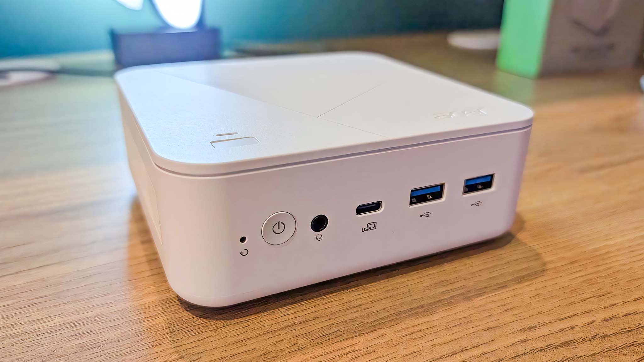 Acer Revo Box AI ahşap bir masa üzerinde.