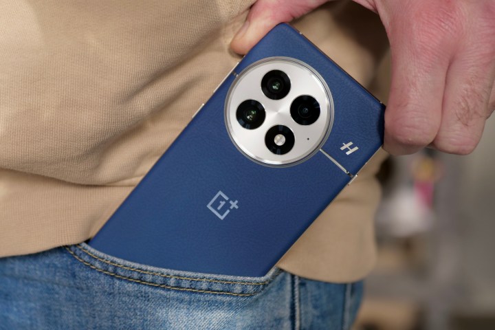 OnePlus 13'ü cebinden çıkaran bir kişi.