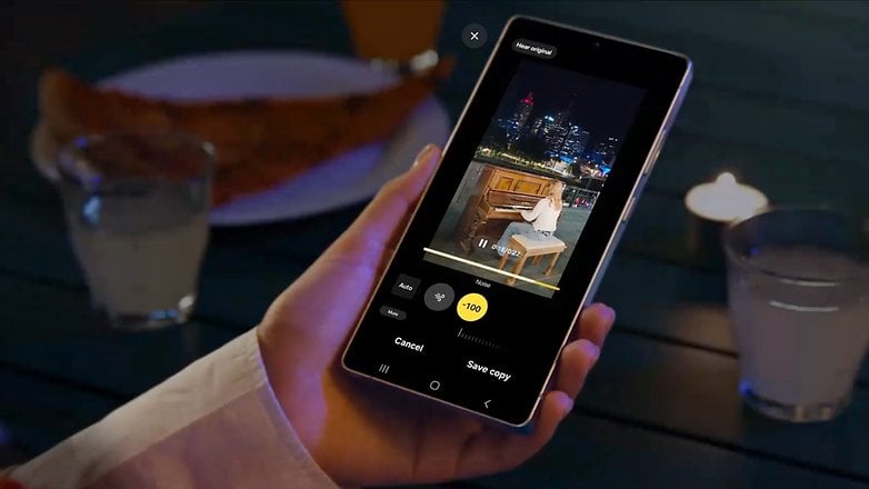 Bir kişi Samsung Galaxy S25 Ultra'yı tutuyor ve şehir siluetinin önünde bir piyanistin videosunu düzenliyor.